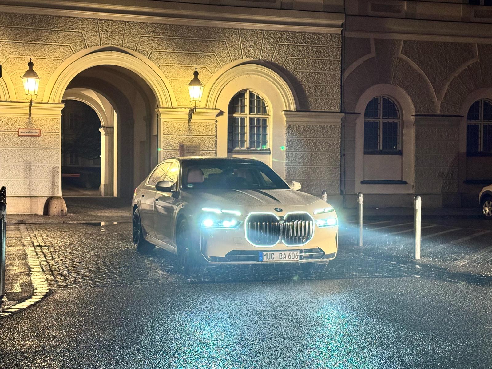 Taxi Adali BMW leicht schräg von vorne bei Nacht vor beleuchtetem Torbogen